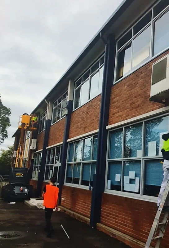 Exterior spray painting of brick commercial building